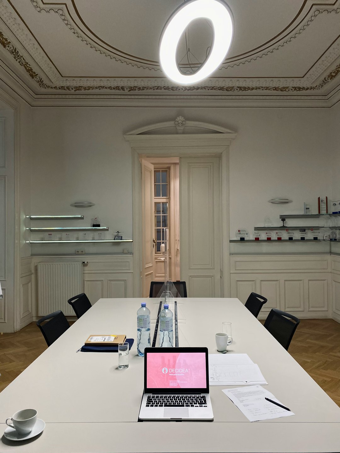 Pusta sala konferencyjna z otwartym laptopem na stole.